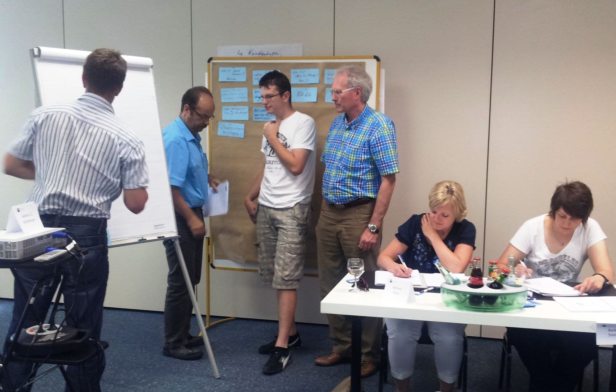 Trainingsgruppe erarbeitet gemeinsam Ergebnisse am Flipchart